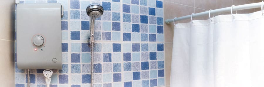 A wall-mounted water heater installed beside a shower in a tiled bathroom, a common setup in Singapore HDB flats and condos.