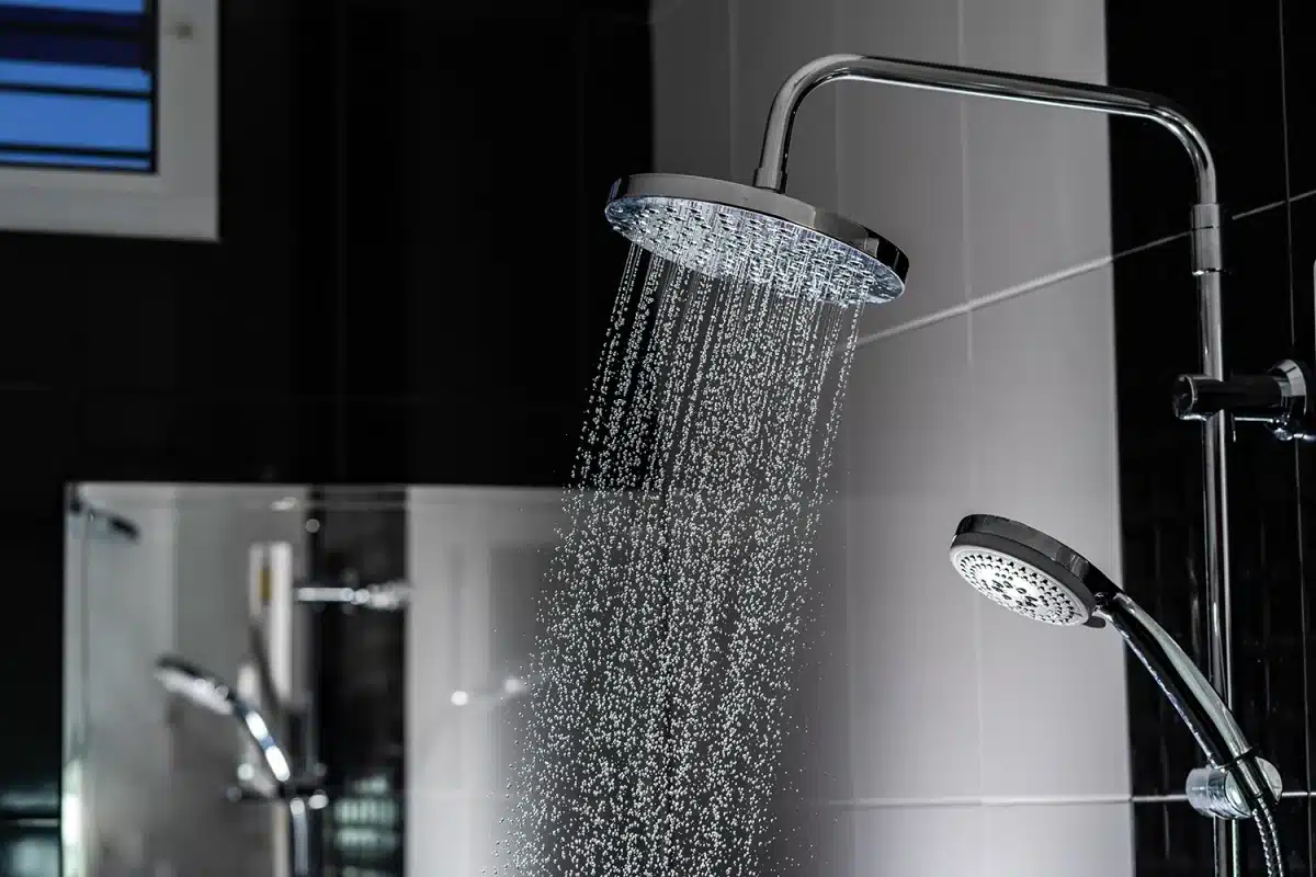 Rain shower head in action, showing the wider water flow that sets it apart from a standard handheld shower